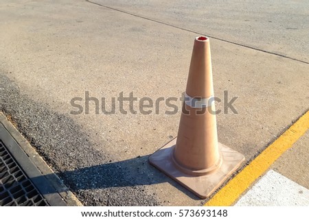 silhouette traffic cone on concrete road, sun light on right side