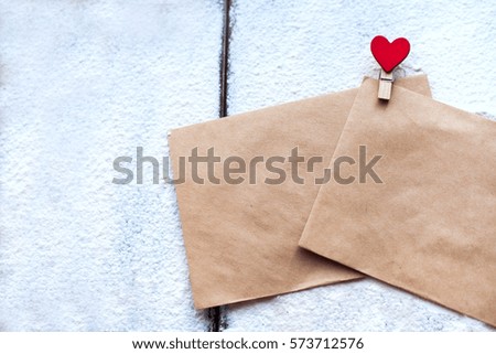 Two the envelope of the Kraft paper clip in the shape of a heart in snow on Valentine's day, people's attitudes