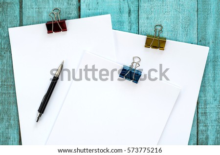 Blue wooden desk table with paper reams and pen. Top view with copy space, flat lay.