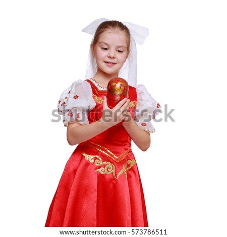 Little girl holding wooden doll in tradition style Hohloma (a brand of Russian traditional ornaments used for painting on wooden things)/Beautiful young girl with russian matreshka