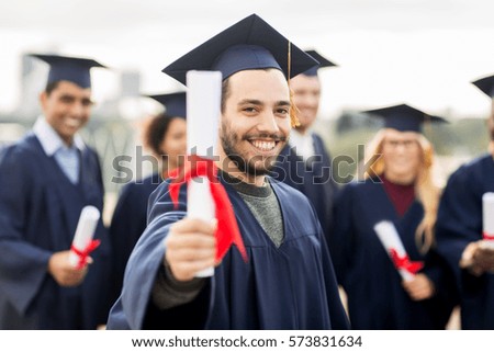 education, graduation and people concept - group of happy international students in mortar boards and bachelor gowns with diplomas Royalty-Free Stock Photo #573831634
