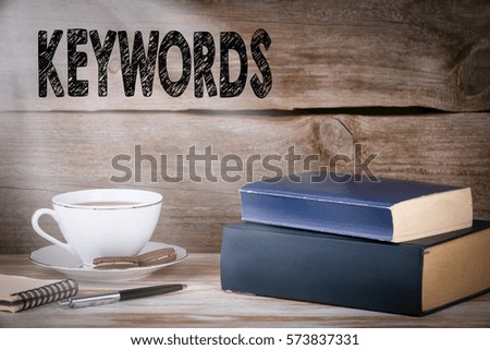 Keywords. Stack of books on wooden desk