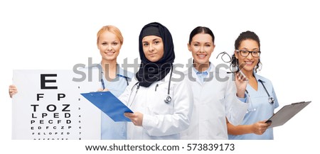 medicine, healthcare, vision and people concept - smiling female doctors white coats with clipboards, eye chart and glasses