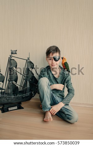in the room on the floor and black sailboat sits a boy pirate with a parrot in a large