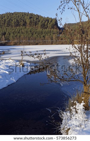 winter landscape with frozen lake on a sunny day         