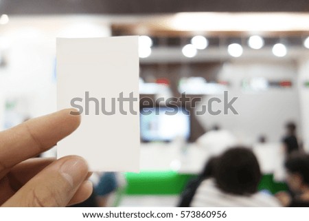 Man is holding queue card while waiting in the bank  area                               