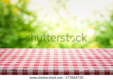 Red checkered tablecloth texture top view with abstract green bokeh from garden in morning background.For montage product display or design key visual layout. Royalty-Free Stock Photo #573868720