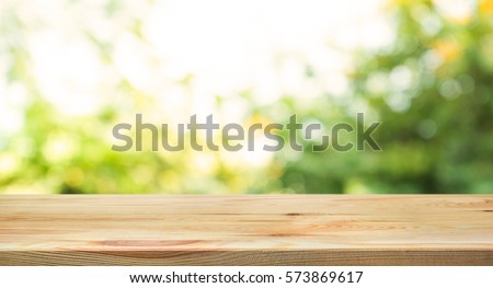 Wood table top on blur abstract green from garden in the morning background.For montage product display or design key visual layout