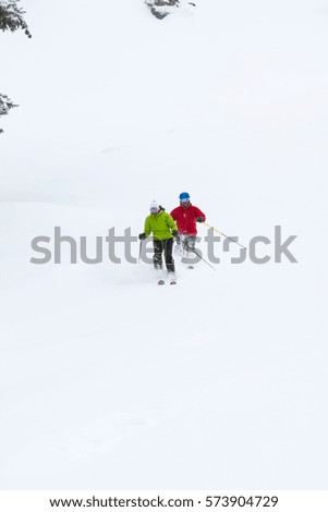 Two skiers, skiing downhill, low angle view