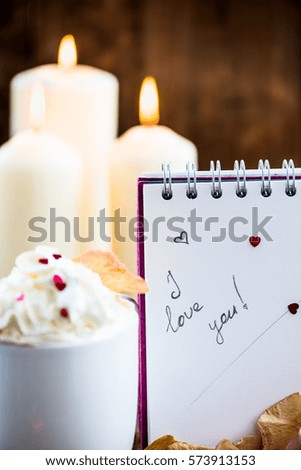 I love you note in the Valentine Day Settings with Rose Petals, Confetti Hearts, Cup of Hot Chocolate and Chocolate Sweets