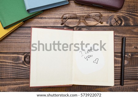 Open book with the inscription "I love you" on a wooden background