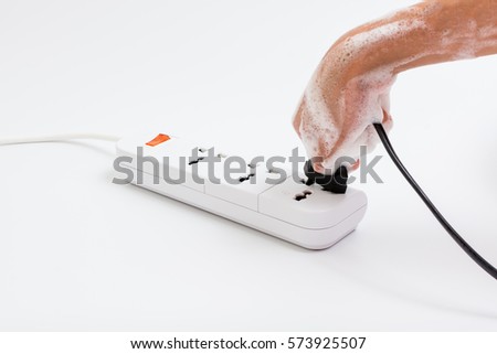 Wet hand of children are plugged. Concept of do not use electricity with wet hand and safety of children. Royalty-Free Stock Photo #573925507