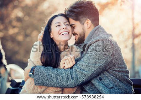 Happy young couple hugging and laughing outdoors. Royalty-Free Stock Photo #573938254