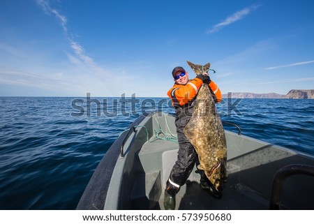 fisherman in the middle of the sea with a huge fish