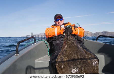 Fisherman holding the tail of a huge fish. horizontal frame