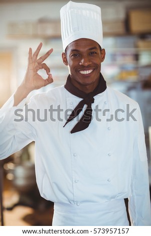 Portrait of happy chef making ok sign in commercial kitchen