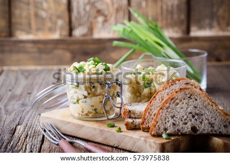 Egg dip sandwich with spring green onion for healthy and delicious brunch on rustic wooden chopping board