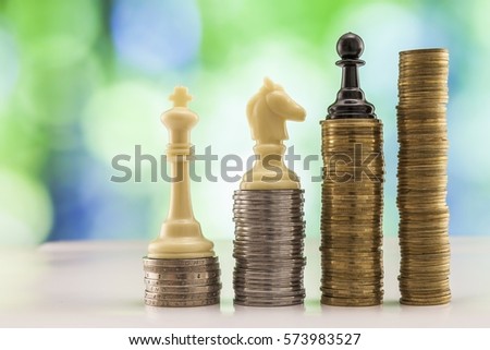 Growing coins stacks with sparkling bokeh background. Chess figures standing on coins meaning power and career growth. Financial growth, saving money, business finance wealth and success concept.