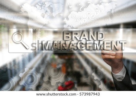 Businessman draws "Brand Management" on the virtual screen. Touch Screen. Virtual Icon. Graphs Interface. Business concept. Internet concept. Digital Interfaces