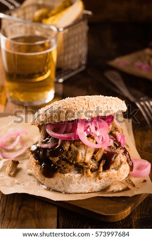 Pulled pork burger with pickled onion on dark wooden background