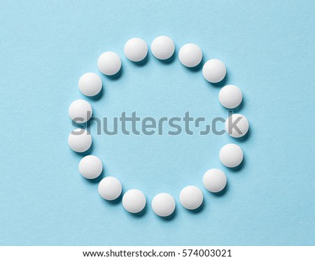 white pills on blue background, top view