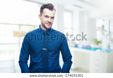 Handsome stylish young man in shirt looking at the camera. Office worker. Business decisions. Beautiful light background