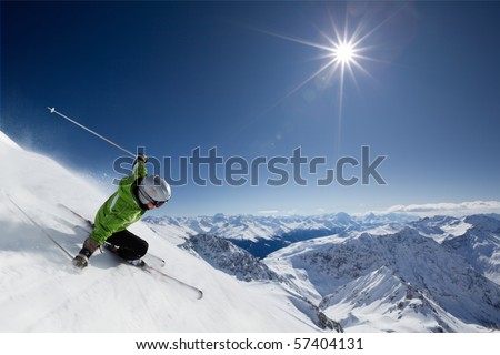 Female skier on downhill race with sun and mountain view.