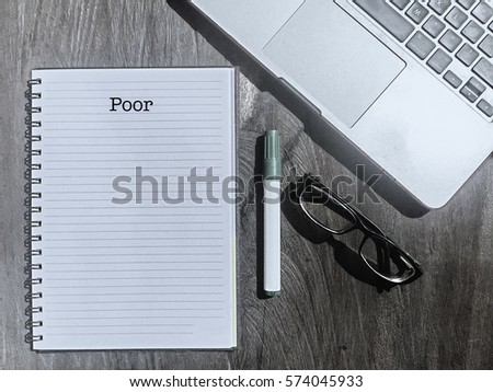 Poor : Typed Words On a handbook with note book, marker pen and notebook. Banking and Financial conceptual. Vintage and classic background mood with noise.