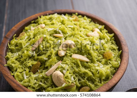 Lauki / Doodhi ka Halwa is Indian popular sweet dish made up of bottle gourd and garnished with dry fruits, consumed hot. Served in a bowl over colourful / wooden background. Selective focus