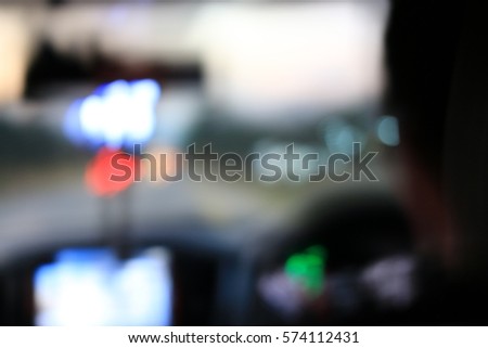 Night road view from inside car natural light street and other cars is motion blurred, Blur image from inside a car traveling at night time.
