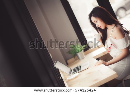 Business woman with laptop and financial charts on the table in coffee shop.