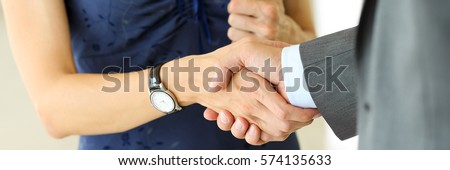 Businessman and woman shake hands as hello in office closeup. Friend welcome, introduction, greet or thanks gesture, product advertisement, partnership approval, arm, strike a bargain on deal concept Royalty-Free Stock Photo #574135633
