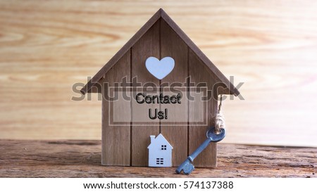 Conceptual image of miniature home icon made from wood and word written CONTACT US! on wooden base.Selective focus.