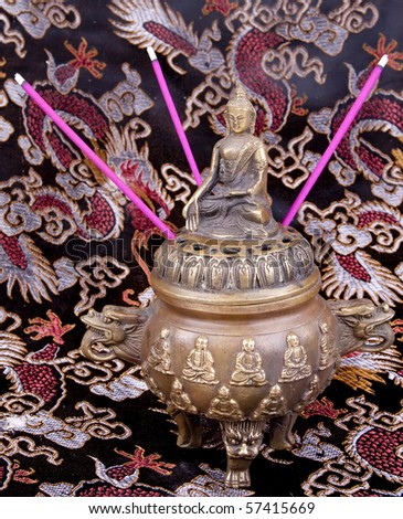 Buddha idol with incense sticks Royalty-Free Stock Photo #57415669