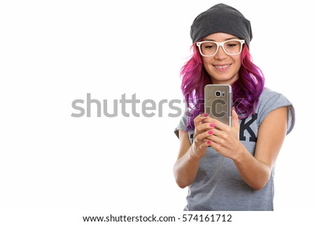 Studio shot of happy geek girl smiling while taking picture with mobile phone
