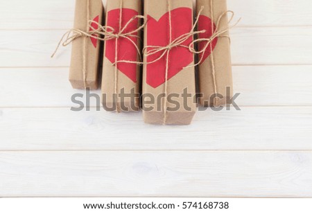 Gift box with hearts. Kraft paper. Background of white wood.