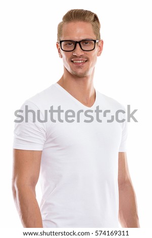 Studio shot of happy young handsome man smiling while wearing eyeglasses