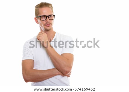Studio shot of young handsome man thinking while wearing eyeglasses