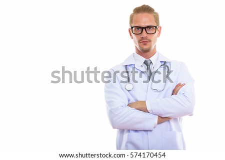 Studio shot of young handsome man doctor with arms crossed