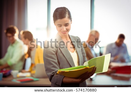 Businesswoman looking at the document in office