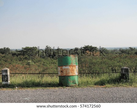  green bucket on street side view in glass field and mountain background 
