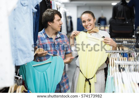 happy pair chooses clothes at the store