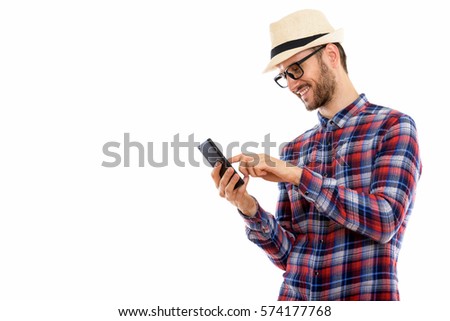 Profile view of happy young man smiling while using mobile phone
