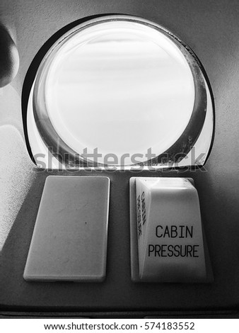 White light indicator and Cabin pressure warning light at viewing window in the airplane