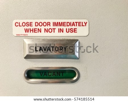 Vacant sign and safety instruction at lavatory door in the airplane