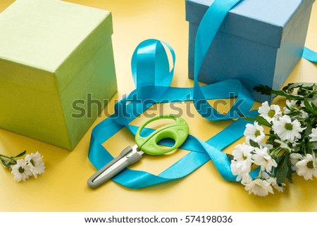 wrapping gifts in box for holiday on yellow background