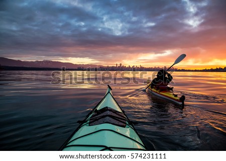 Kayakers enjoying the beautiful sunrise. Picture taken near Kitsilano Beach, Vancouver, BC, Canada. Royalty-Free Stock Photo #574231111