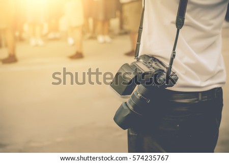 photographer holding camera, close-up.Vintage tone.