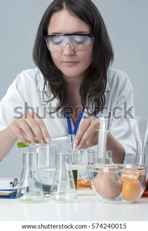 Female Laboratory Staff Dealing with Color Chemicals in Laboratory. Vertical Image