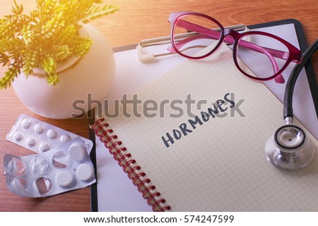 Stethoscope on note book with Hormones words as medical concept Royalty-Free Stock Photo #574247599